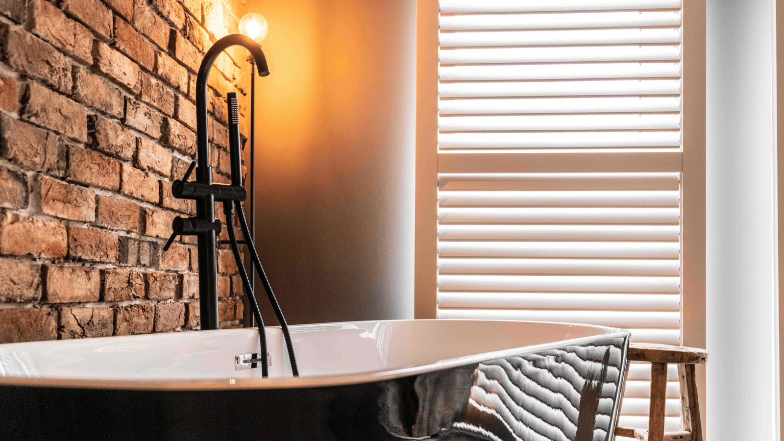 Design-Badezimmer mit freistehender Wanne und Ziegelwand – hochwertige handgeformte Riemchen sorgen für warme Vintage-Atmosphäre