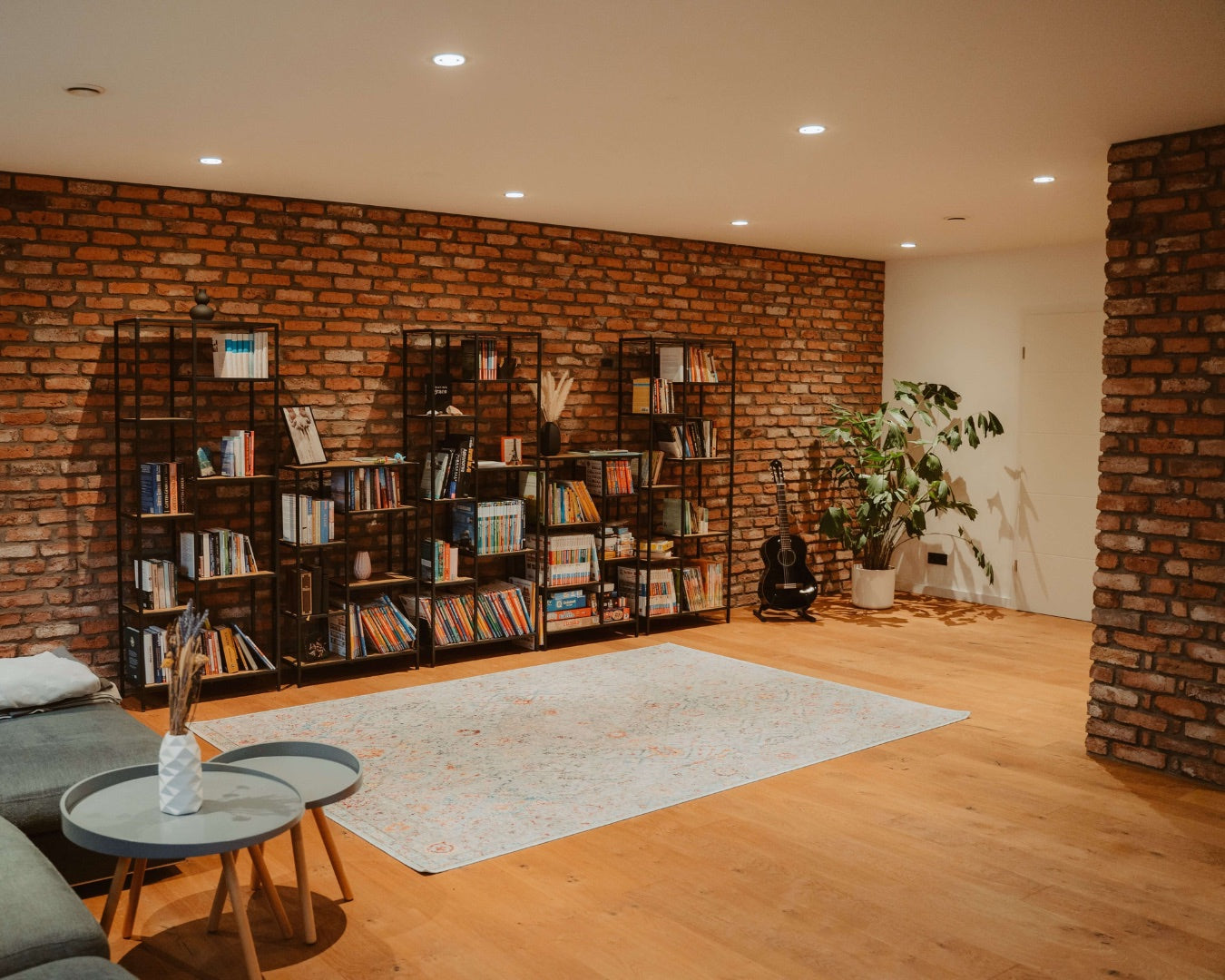 Modernes Wohnzimmer mit rustikaler Ziegelwand, verkleidet mit Ziegelriemchen aus recycelten Altziegeln – stilvolle Innenraumgestaltung im Loftstil