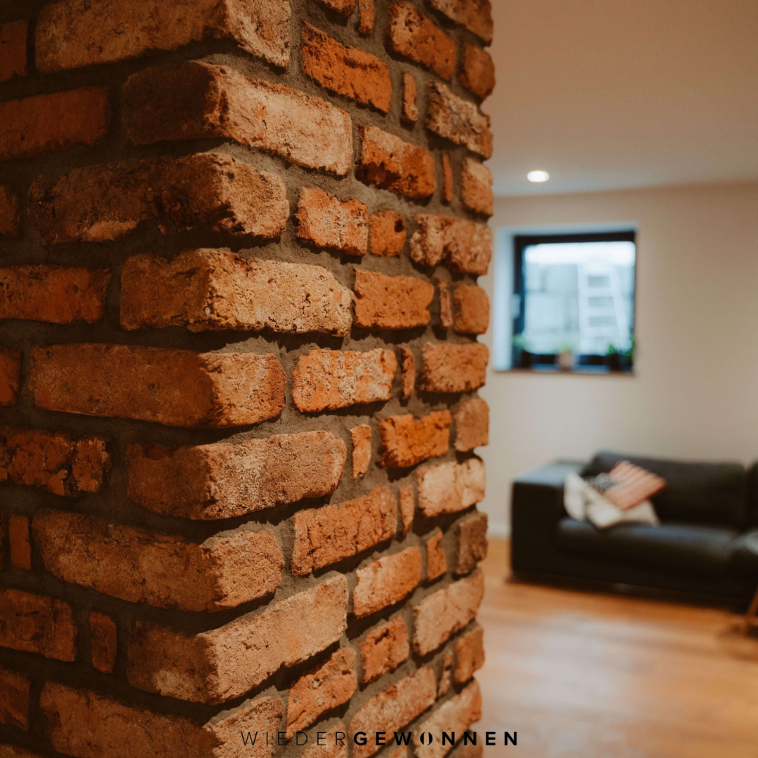 Detailaufnahme einer Ziegelsäule im Wohnzimmer, gemauert aus recycelten Altziegeln – rustikale Struktur für authentische Backsteinoptik mit Charakter